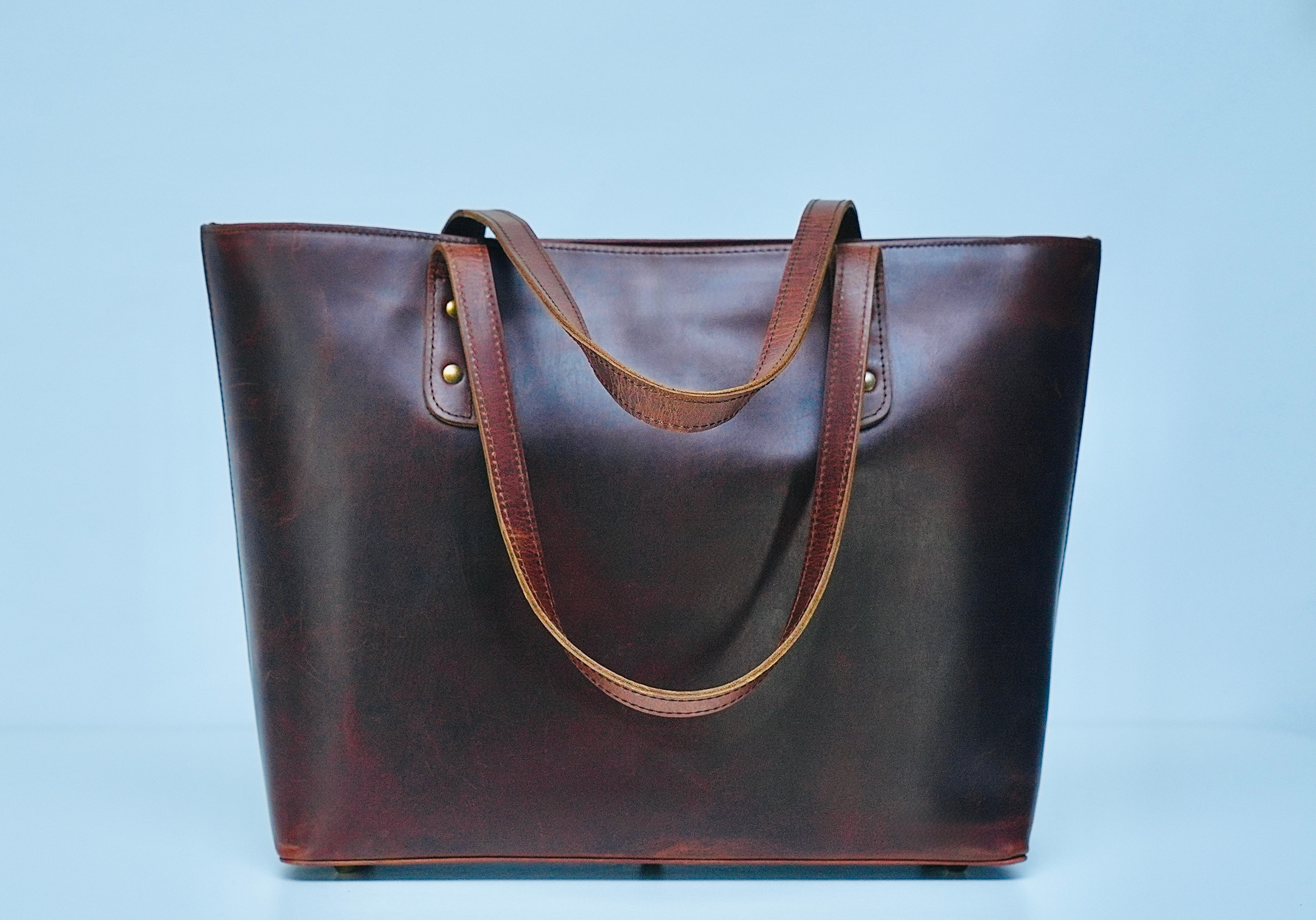 Oxblood full-grain leather tote showing natural grain